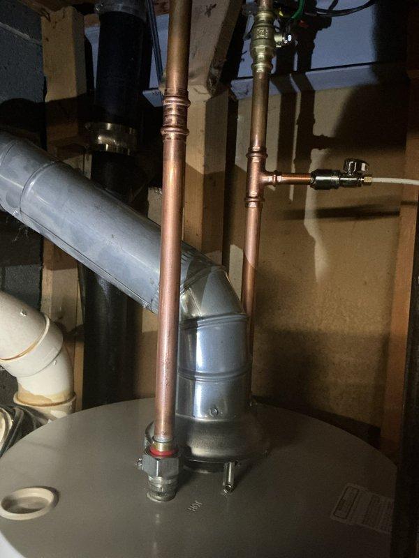 Responded to service call for leaking water heater in 15-year-old residential property. Upon inspection, confirmed active leak from aging tanked water heater unit that had reached end of serviceable life. Documented existing plumbing configuration including copper supply lines with brass valves and compression fittings, as well as connected expansion tank and HVAC components in mechanical utility area. Verified tank alignment and assessed overall installation condition. Recommended full water heater replacement due to age-related deterioration and active leak presenting risk of water damage.