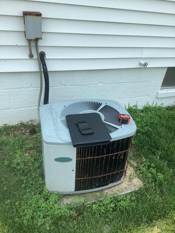 Conducted comprehensive AC system evaluation for complete HVAC replacement estimate. Assessed existing Carrier furnace installation in basement mechanical room along with outdoor condenser unit positioned on concrete pad adjacent to structure. Documented current system configuration including ductwork distribution, refrigerant line routing through exterior wall penetration, electrical service connections, and overall equipment condition. Photographed both indoor and outdoor components to support replacement proposal specifications and equipment sizing requirements.