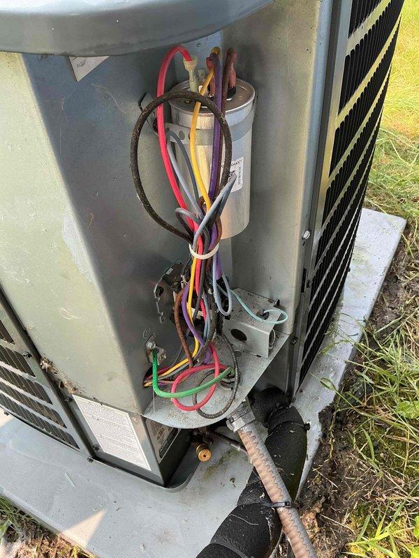 Completed maintenance tune-up on 4-year-old Goodman ground-level condenser unit. Performed standard preventative maintenance procedures including inspection of electrical components, capacitor testing, and system operational check. Customer reported home temperature reaching 80 degrees with insufficient airflow through supply and return vents; diagnostic assessment revealed undersized air conditioning system for square footage of residence. Pressure readings indicated 300 CFM at all supply vents except one register measuring 1700 CFM, suggesting possible ductwork restriction or damper imbalance. Inspected condenser coil, fan motor operation, and refrigerant lines during service visit. Accessed internal components through side panel to verify electrical connections and capacitor function. Recommended system evaluation for potential replacement due to inadequate cooling capacity for home size and airflow distribution issues requiring further investigation of duct system design and sizing