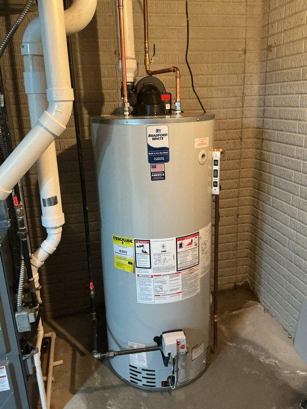 Installed a 75-gallon Bradford White residential water heater in basement utility area, connecting all necessary copper supply lines, electrical wiring, temperature and pressure relief valve, and gas connections. The unit was properly positioned against the concrete block wall with all piping, venting, and safety controls installed per manufacturer specifications and local plumbing codes.