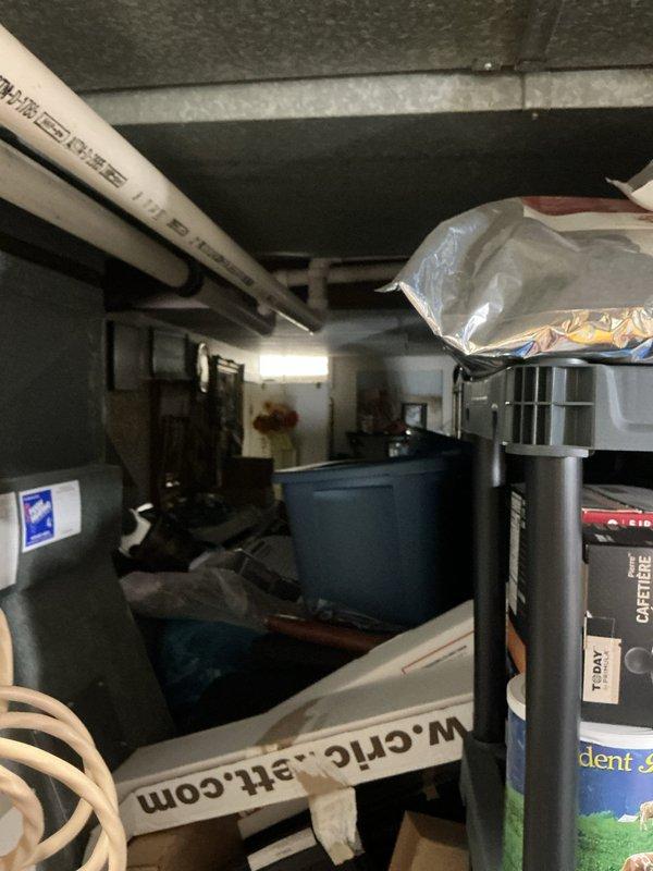 Responded to no cooling complaint on 47-year-old Lennox Pulse system with noise and drainage leak issues affecting entire home. Upon inspection, found unit had reached end of serviceable life with multiple component failures including compromised condensate drainage system causing water leakage at drain pipe. Documented existing equipment condition with photos showing aged furnace/HVAC unit in basement location with visible PVC venting and surrounding utility area. Advised customer that 1979-era Lennox Pulse system requires immediate replacement due to age, obsolete parts availability, and current system failures preventing proper operation and cooling capacity.