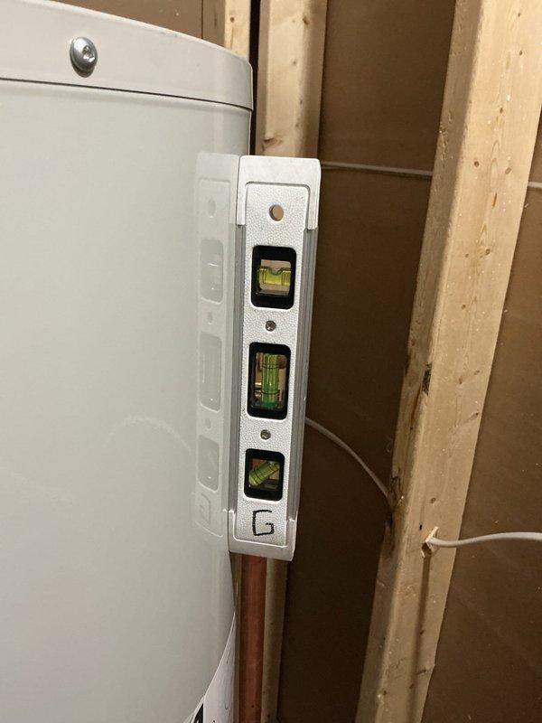 Responded to emergency service call for Bradford White tank water heater experiencing recurring leak from top connections, which had caused approximately 2 inches of standing water accumulation in finished basement area. Upon arrival, inspected all top-mounted connections, piping, and fittings; identified source of leak at improperly sealed connection point. Tightened and resealed affected connections, verified proper alignment of unit using level to ensure no stress on piping, and conducted pressure test to confirm leak was fully resolved with no further water discharge detected.