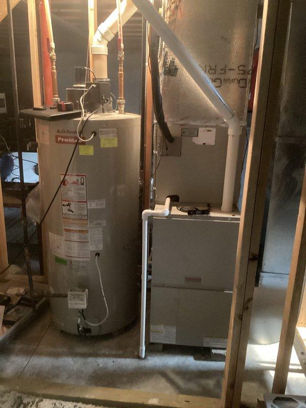 Conducted comprehensive site assessment for complete air conditioning system replacement at residential property. Evaluated existing outdoor condensing unit positioned on foundation mulch bed with refrigerant lines running to junction box, and inspected indoor air handler unit located in basement mechanical room alongside water heater. Documented current system configuration including copper line sets, electrical connections, and ductwork layout. Provided detailed estimate for replacement of both outdoor condensing unit and indoor air handler components with updated equipment to improve cooling efficiency and system performance.