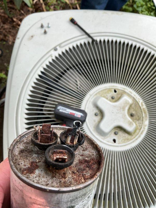 Responded to no cooling complaint on residential air conditioning system. Upon inspection, found failed dual run capacitor on outdoor condensing unit with significant corrosion and rust on terminals and casing. Replaced defective capacitor with new unit, verified proper microfarad ratings, and tested system operation. Unit now cooling properly with normal amperage draw and temperature split.