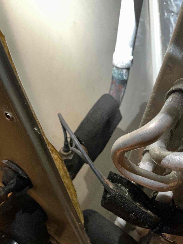 Performed diagnostic assessment on residential air conditioning system. Upon arrival, communicated with customer that full system diagnosis would be required before proceeding with leak search and leak seal services. Connected refrigerant manifold gauges to measure system pressures, recording operating pressures and temperatures. Visual inspection revealed significant frost accumulation on refrigerant suction line, indicating potential restriction, low refrigerant charge, or metering device malfunction. Documented system conditions with photos showing pressure readings and frosted copper line with oxidation present. Deferred leak search procedure pending completion of comprehensive diagnostic evaluation to properly identify root cause of system malfunction.