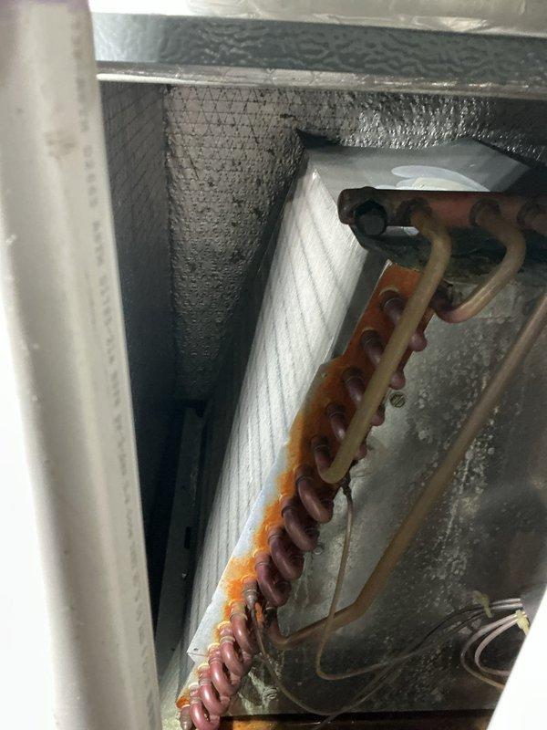 Responded to callback for persistent water leakage in basement from recently installed air conditioning unit. Upon inspection, identified active water infiltration with significant moisture damage to basement walls and concrete floor pooling. Examined air handler unit and refrigerant line configuration, noting oxidized copper tubing and compromised condensate drainage system. Traced leak source to improper condensate line installation or blocked drain pan causing overflow. Corrected drainage issue, verified proper pitch and flow of condensate lines, cleared any blockages, and tested system operation to confirm leak resolution and proper water evacuation.
