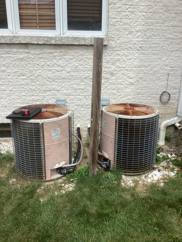 Completed comprehensive assessment of existing HVAC system for full replacement estimate. Evaluated current basement-installed furnace and air handler units, documenting internal components, wiring configurations, and existing ductwork connections. Inspected two outdoor condenser units showing significant weathering and age-related deterioration. Photographed all equipment including exposed electrical components, refrigerant line connections, PVC drainage piping, and galvanized ductwork routing. Provided detailed replacement recommendations for complete heating and cooling system upgrade based on observed equipment condition and installation specifications.