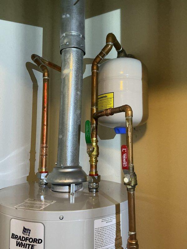 Responded to service call for non-operational 10-year-old Bradford White natural gas water heater. Performed diagnostic evaluation of unit and associated components including vent piping, copper supply lines, expansion tank, and safety valves. Assessed overall system condition, verified proper venting configuration with galvanized flue pipe, and inspected plumbing connections with brass fittings. Documented existing installation with expansion tank, multiple shut-off valves, and control box. Provided customer with assessment findings and replacement recommendations based on unit age and current operational status.