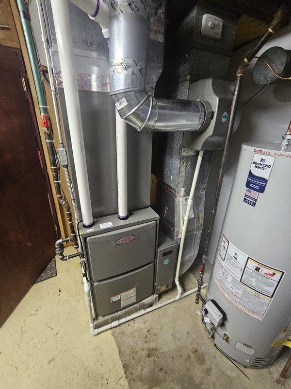 Completed full HVAC system replacement including installation of 96% efficiency upflow furnace rated at 110,000 BTU with matching upflow cased coil certified under AHRI 215580639. Installed new 7/8" x 50' refrigerant line set, metal filter rack sized for 20x25x5 media filters, and 17-gallon whole-house humidifier with new evaporator pad. Replaced 50-gallon residential water heater in basement utility room. All ductwork connections secured with proper metallic tape and fasteners. Installed new electrical disconnect and whip for furnace power supply. Upgraded thermostat to provide system control. Verified level installation of all equipment on concrete pad, tested all connections for proper operation, and confirmed adequate clearances per manufacturer specifications and local code requirements.