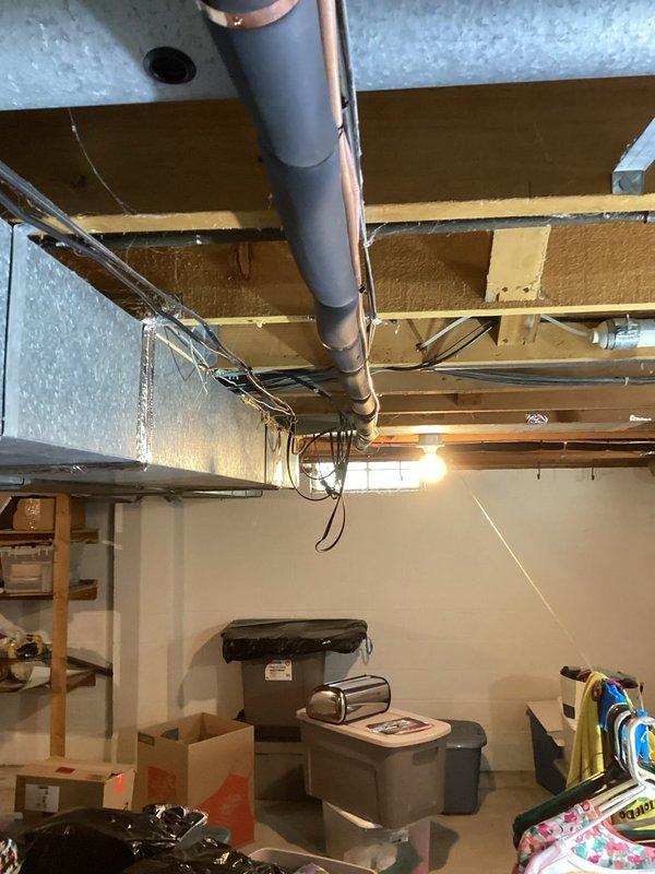 Completed installation of single-stage air conditioning system with upflow cased coil in basement location. Installed new 3/4-inch line set measuring 30 feet, relocated condenser unit 3 feet from electrical panel onto new equipment pad while leaving existing pad in place for condensate pump. Installed new disconnect and whip for proper electrical connection, and successfully reused existing Emerson digital thermostat to maintain customer preference and reduce costs.