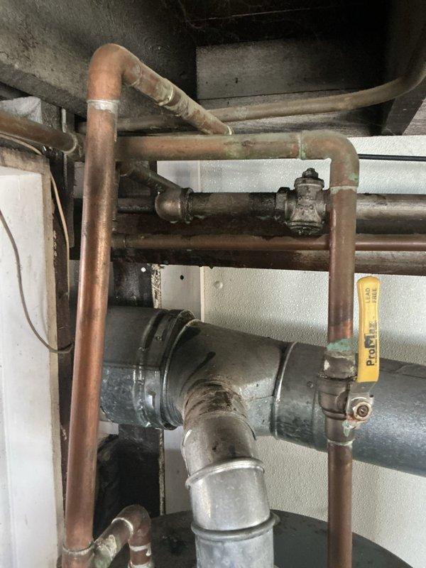 Responded to gas leak emergency per gas company requirement. Conducted comprehensive pressure test on residential gas piping system to identify leak location and verify system integrity. Inspected aged copper gas distribution network including multiple horizontal and vertical pipe runs, isolation valves, and circulation components showing significant oxidation and patina consistent with older installation. Performed systematic pressure testing protocol to isolate compromised section and documented existing piping conditions throughout basement utility area. System evaluated and findings documented with photographic evidence for gas company verification and customer records.