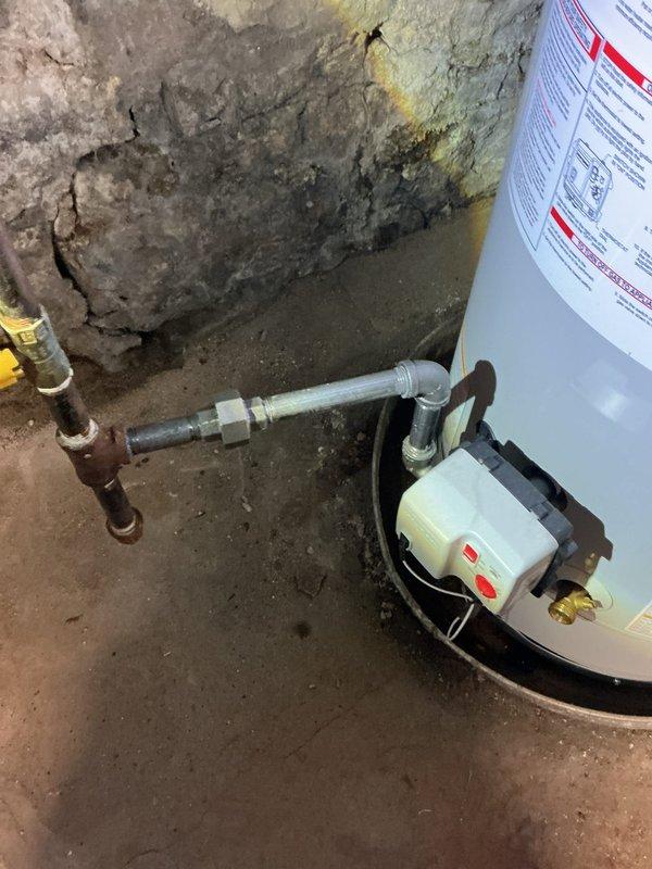 Completed installation of a 40-gallon power vent water heater in basement utility area. Removed existing unit and installed new water heater on stable base platform, connecting supply and discharge lines with flexible connectors and brass fittings to accommodate existing plumbing infrastructure. Verified level installation, proper venting configuration, and tested all connections for leaks prior to system activation.