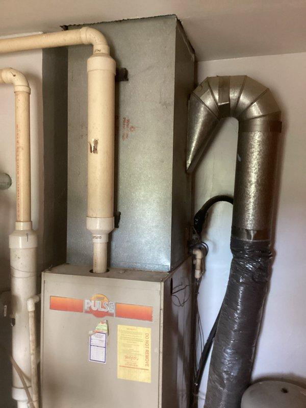 Conducted comprehensive HVAC system evaluation for existing Pulse furnace installation with associated ductwork and venting components. Assessed current equipment condition, measured system specifications, documented installation configuration including PVC condensate drainage, metal supply plenum, and flexible ductwork connections to provide detailed replacement estimate and equipment recommendations.