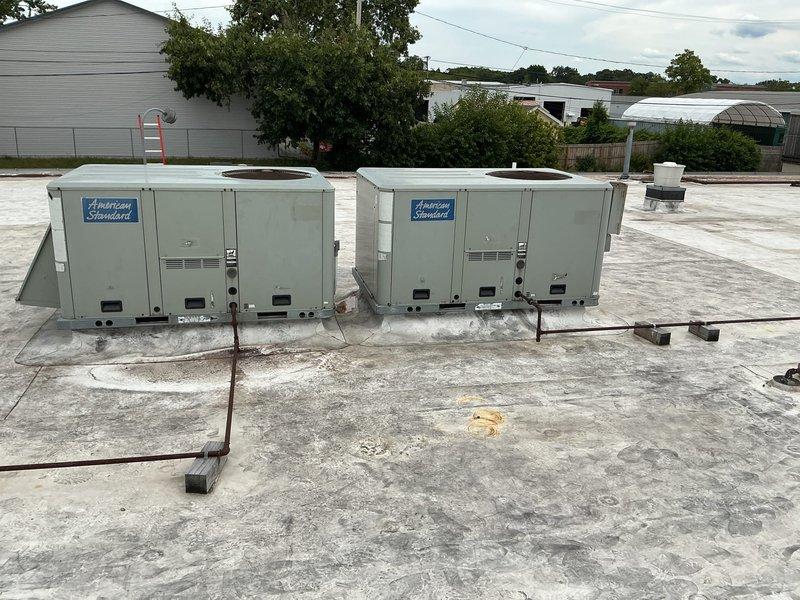 Conducted site assessment of two American Standard rooftop package units on commercial flat roof installation. Documented current equipment condition through photographs, verified unit model information, and took detailed measurements of both units to determine replacement specifications. Inspected access panels, internal components, electrical conduit connections, and mounting configurations to ensure accurate parts identification and sizing for upcoming replacement project.