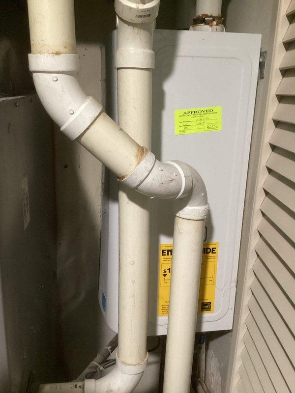 Completed comprehensive evaluation of existing HVAC system for furnace and air conditioning replacement. Assessment included documentation of current equipment configuration, existing PVC venting system with visible corrosion at pipe connections, and electrical panel setup in utility area. Identified aging components with rust staining at drainage connections and wear on existing infrastructure requiring attention during replacement installation.