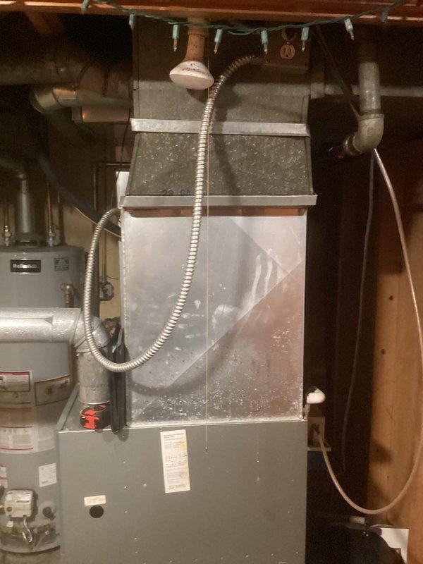 Conducted comprehensive assessment of existing HVAC system in residential basement utility area to provide replacement estimate for furnace and air conditioning equipment. Documented current installation configuration including furnace unit, ductwork connections, condensate drainage system, refrigerant line routing, and electrical conduit placement. Evaluated equipment accessibility, venting requirements, and spatial constraints for new system installation. Photographed existing setup showing furnace positioned against concrete block wall with associated PVC venting, copper refrigerant lines, and metal ductwork connections to facilitate accurate equipment sizing and replacement planning.
