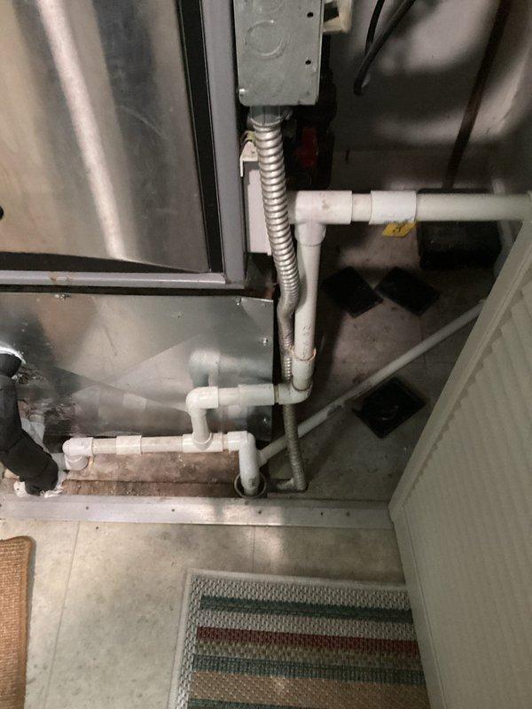 Conducted comprehensive evaluation of existing HVAC system for equipment replacement estimate. Assessed vertically-stacked furnace and air handler installation housed in interior utility closet with confined access. Documented current system configuration including stainless steel furnace unit, horizontal evaporator coil with visible rust staining and moisture damage, white PVC condensate drainage lines, and electrical conduit connections. Photographed equipment condition, piping arrangements, and spatial constraints for replacement planning. Provided estimate for complete furnace and air conditioning system replacement to address aging equipment and potential recall concerns.