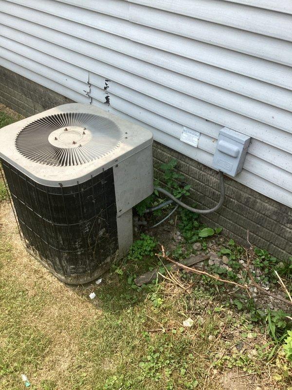 Conducted on-site evaluation for complete HVAC system replacement at residential property. Assessed existing outdoor condenser unit showing significant weathering, dirt accumulation, and age-related deterioration on exterior housing. Documented current refrigerant line routing, PVC conduit configuration along exterior wall, and ground-level placement adjacent to foundation. Evaluated indoor furnace unit located in basement alcove, noting existing ductwork connections and electrical service panel proximity. Provided comprehensive replacement estimate for new air conditioning condenser and furnace system to address equipment age and operational concerns.