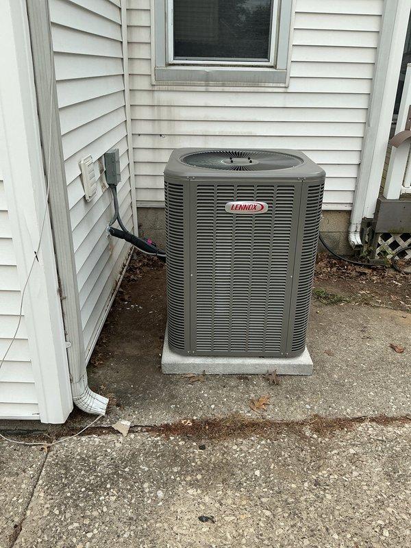 # HVAC Complete System Installation

Completed full residential HVAC system installation consisting of an 80% AFUE upflow furnace in A-cabinet configuration, 2-ton evaporator coil, and 2-ton Lennox condensing unit (AHRI Certificate #215580245). The outdoor condensing unit was positioned on a concrete pad against the exterior wall with proper clearances maintained for adequate airflow around all louver panels. Electrical disconnect box was mounted to exterior siding for code-compliant service accessibility. Black electrical conduit and wiring were routed from the building to the condensing unit. The upflow furnace and evaporator coil were installed indoors per manufacturer specifications to match the outdoor unit capacity. All refrigerant lines were properly connected, evacuated, and charged. System was tested for proper operation including airflow verification, electrical connections, and thermostat communication. Installation meets all applicable building codes and manufacturer requir