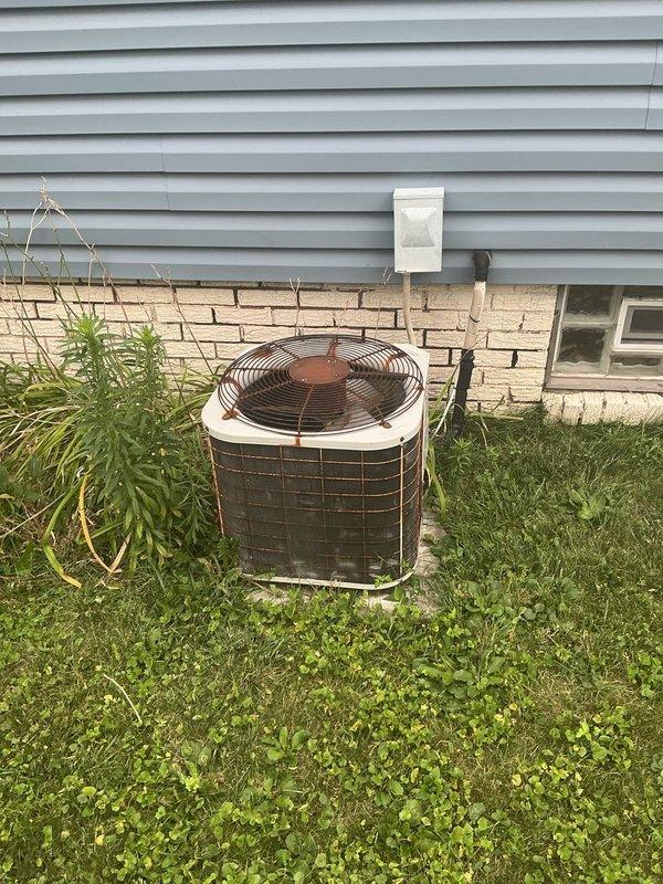 Responded to service call for furnace leaking water. Upon inspection, opened furnace cabinet and examined internal components, blower assembly, and condensate drainage system. Photographed outdoor condensing unit and indoor furnace installation to document system configuration and identify source of water leak.
