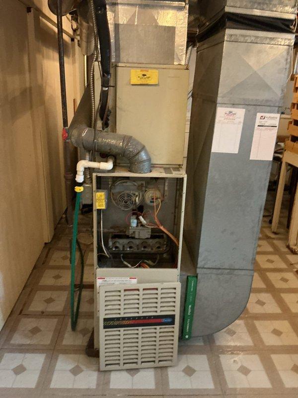 Responded to service call for furnace leaking water. Upon inspection, opened furnace cabinet and examined internal components, blower assembly, and condensate drainage system. Photographed outdoor condensing unit and indoor furnace installation to document system configuration and identify source of water leak.