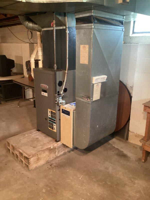 Completed comprehensive quote finalization for basement HVAC system replacement featuring Lennox furnace installation. Documented existing equipment setup including furnace unit mounted on masonry platform, metallic ductwork configuration, and auxiliary mechanical systems in unfinished basement utility area. Captured detailed photographic documentation of current installation specifications, manufacturer labeling, and spatial layout to support replacement proposal development.