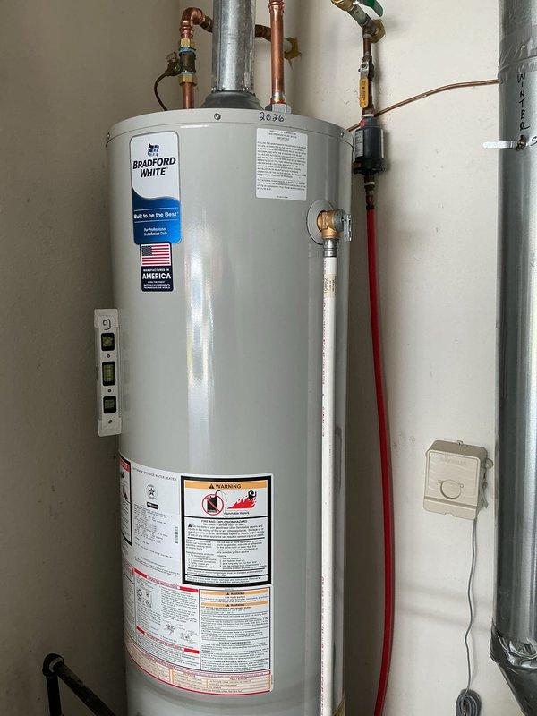 Completed installation of a 40-gallon slim Bradford White residential water heater with proper copper piping connections, brass fittings, and galvanized venting system. Additionally installed a surge protector at the outdoor electrical disconnect on the exterior equipment, ensuring power was safely disconnected prior to installation.