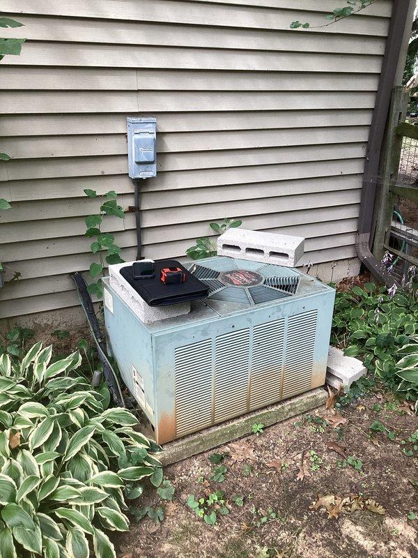 Conducted comprehensive assessment of existing HVAC system for complete replacement estimate. Evaluated outdoor air conditioning condenser unit showing significant age-related deterioration including rust staining and weathering on exterior cabinet and base components. Inspected electrical disconnect box and reviewed accessibility for equipment removal and new unit installation on existing concrete pad. Assessed basement mechanical room containing furnace, ductwork system, and associated components including vertical and horizontal supply and return air distribution network. Documented current system configuration including black cylindrical ductwork, metallic elbows, and existing humidifier integration points. Provided detailed replacement recommendations for furnace, air conditioning condenser, and whole house humidification system to restore efficient climate control and improve system reliability.
