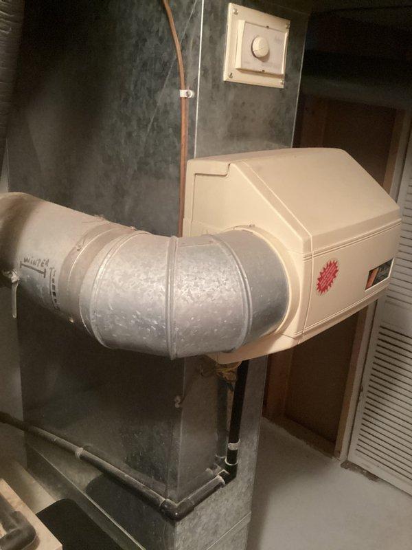 Completed comprehensive assessment of existing HVAC system for air conditioning replacement estimate. Documented current equipment configuration including furnace, humidifier unit with integrated controls, and existing ductwork system. Inspection revealed significant rust and corrosion throughout metal ductwork, particularly at joints and seams of upper plenum and vertical supply connections, indicating moisture exposure and age-related deterioration. Evaluated complete system layout in basement mechanical room, noting copper refrigerant lines, flexible duct connections, and overall equipment placement. Photographed existing installation to document pre-replacement conditions and identify scope of work required for AC system upgrade. Provided detailed estimate for air conditioning replacement based on current system assessment and observed equipment conditions.