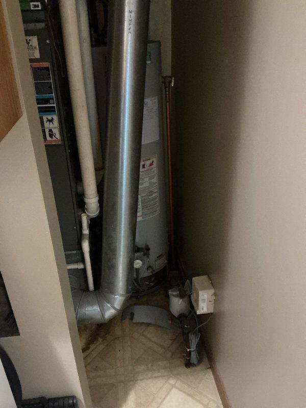 Responded to service call for leaking water heater. Upon arrival, inspected 10-year-old residential tanked water heater located in utility closet alongside HVAC equipment. Conducted visual assessment of unit and surrounding plumbing connections to identify source of leak. Documented existing conditions including water heater installation, associated piping (copper supply lines, PVC drainage, and metal flue vent), and evidence of moisture or water damage. Photographed equipment configuration and closet layout for service records. Provided assessment findings and recommended next steps for leak repair or unit replacement based on age and condition of water heater.