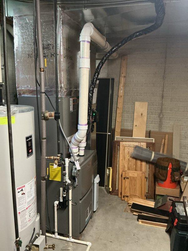 Completed full HVAC system installation including upflow cased coil, single-stage condenser unit, new refrigerant line set, concrete equipment pad, electrical disconnect with whip, and programmable thermostat. All components installed to manufacturer specifications with proper venting, drainage, and electrical connections verified operational.