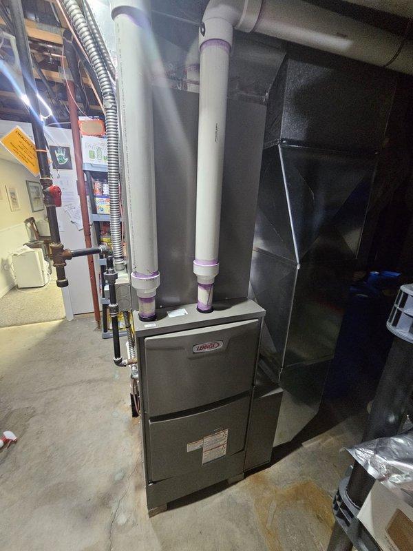 Completed full HVAC system installation in residential basement mechanical room. Installed upflow 96% efficiency two-stage furnace with return base and C-width upflow cased coil. Added 17-gallon whole-home humidifier with 5-inch filter rack for enhanced indoor air quality. Ran new 7/8-inch line set approximately 50 feet to exterior condensing unit. Installed 17 SEER two-stage air conditioning condenser, relocating unit 3 feet forward from electric meter for proper clearance and serviceability. Installed new electrical disconnect and whip for condensing unit per code requirements. Configured Wi-Fi enabled thermostat for remote system monitoring and control. All PVC intake and exhaust venting installed and secured to furnace. Copper refrigerant lines properly insulated and connected. System tested for proper operation including heating, cooling, and humidification functions. All components operating within manufacturer specifications.