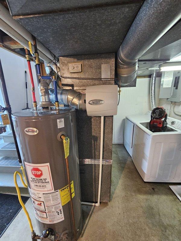 Completed full HVAC system retrofit installation including upflow cased coil air handler in basement utility area and single-stage condenser unit on exterior concrete pad. Installed new 3/4" x 30' lineset, electrical disconnect and whip, and programmed new thermostat for system operation. Repositioned existing Aprilaire humidifier to accommodate new air handler configuration, ensuring proper integration with updated ductwork and maintaining all safety clearances per manufacturer specifications.
