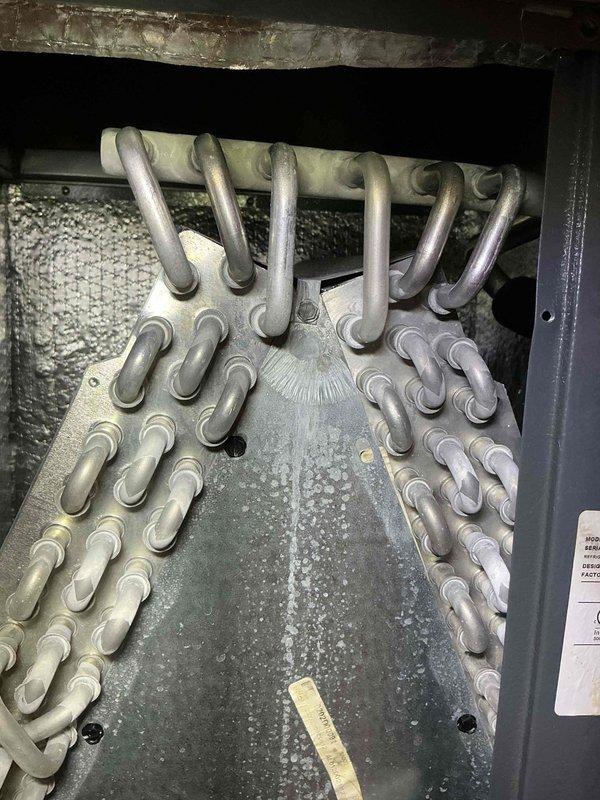 Completed standard air conditioning tune-up service on residential HVAC system. Performed comprehensive inspection of evaporator coil assembly and heat exchanger components, documenting normal operational wear and minor dust accumulation on coil surfaces and base pan. All system components found to be functioning within normal parameters with no immediate service concerns identified.