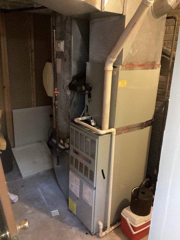 Completed comprehensive estimate for residential furnace replacement in basement utility area. Assessed existing beige-colored furnace unit with current PVC venting configuration and documented equipment specifications, manufacturer labels, and existing ductwork connections. Evaluated mechanical room layout including proximity to A.O. Smith water heater, available clearances, structural considerations with exposed wall studs, and accessibility for future installation and maintenance requirements.