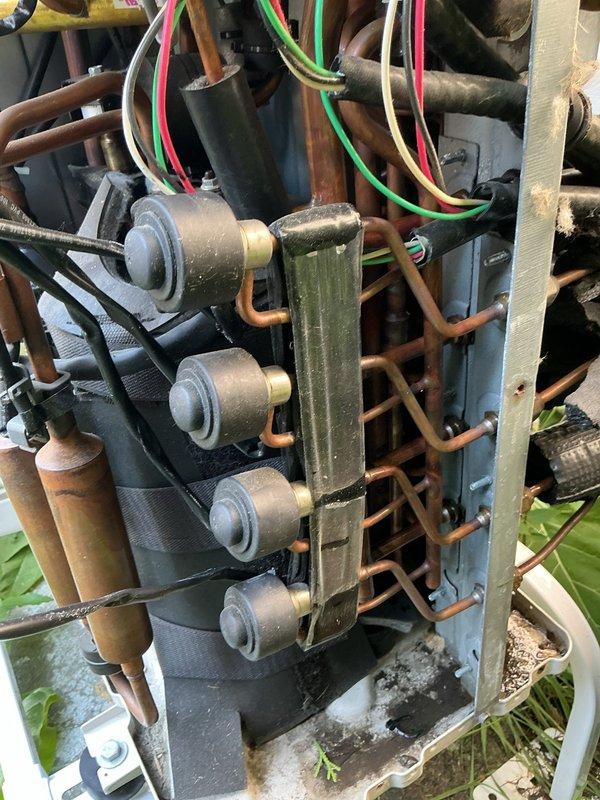 Responded to intermittent cooling issue on a two-year-old mini-split system where upstairs indoor units were randomly losing cooling capacity while other zones continued operating normally. Inspected outdoor unit condensing section and found multiple solenoid valves controlling refrigerant distribution to individual zones, along with the main control board assembly. Upon examination, identified improper installation practices from original non-professional installation, including refrigerant lines routed through unconditioned attic space, which can contribute to inconsistent system performance and potential refrigerant flow issues affecting specific zones unpredictably.