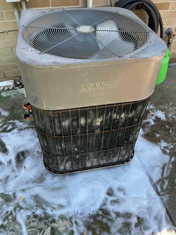 Completed standard air conditioning tune-up on Lennox outdoor condenser unit. Performed comprehensive system inspection, cleaned condenser coils showing weathering and dirt accumulation on vertical fins, verified fan operation and electrical connections, and confirmed unit operational status. System age undetermined at time of service.