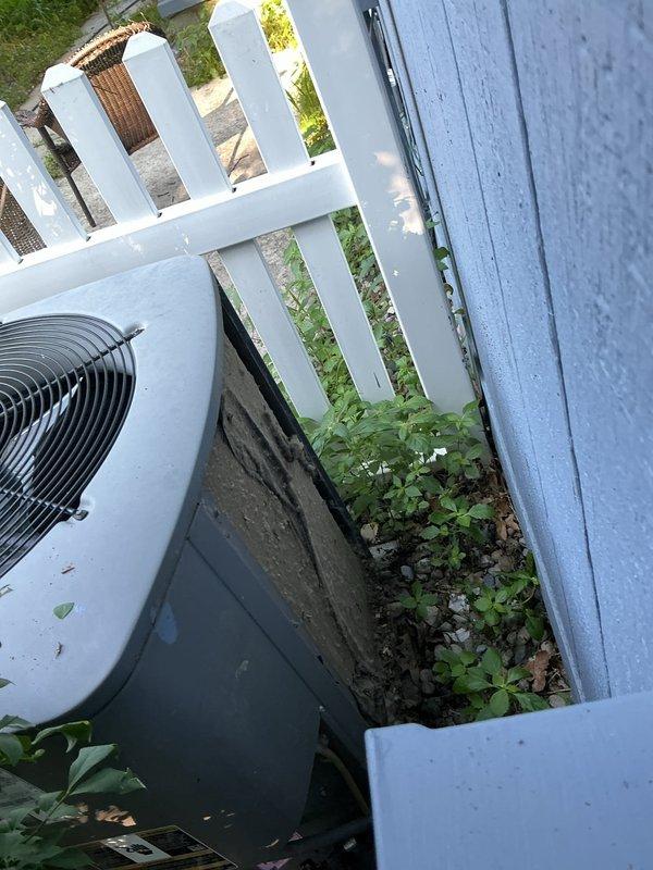 Responded to no cool call on 16-year-old residential air conditioning system. Upon arrival, found condenser unit with heavy accumulation of dirt, dust, and organic debris on interior surfaces and coils, indicating extended period without maintenance. Unit located in confined side yard space with vegetation growth around equipment restricting airflow. Inspected unit for operational issues, documented severely soiled condition affecting system performance and efficiency.