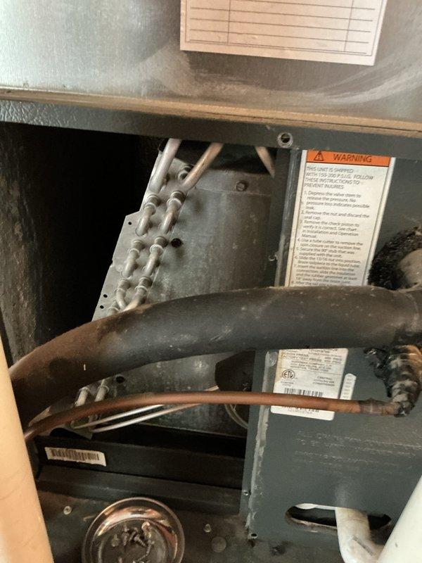 Responded to customer complaint of strong refrigerant odor near AC unit. Performed thorough inspection of indoor evaporator coil assembly and outdoor condensing unit, including all refrigerant line connections and service valves. Visually examined copper line sets, flare connections, and refrigerant piping for signs of leakage or oil residue that would indicate active refrigerant loss. Documented equipment condition with photographs for service records.