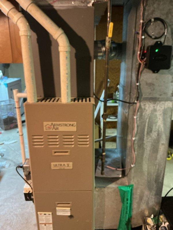Completed full HVAC system installation including Armstrong Air Ultra X upflow furnace with cased B-width evaporator coil in basement location. Installed new 50-foot lineset with 3/4" liquid line connecting indoor coil to outdoor single-stage condenser unit. Relocated condenser 3 feet from electrical meter, setting unit on new concrete pad with proper clearances. Installed new disconnect switch and whip for condenser power supply, along with J-box for electrical connections. Ran refrigerant lines through basement, securing copper piping with appropriate hangers and insulation. Connected evaporator coil to existing ductwork, ensuring proper airflow direction for upflow configuration. Completed all electrical connections including low-voltage control wiring. Reused existing thermostat, verifying compatibility with new equipment and updating system configuration. Evacuated refrigerant lines to proper micron level, charged system to manufacturer specifications, and verified proper superhea
