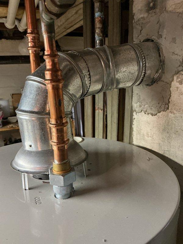 Completed inspection corrections on HVAC installation. Installed locking-type caps on condenser unit per code requirements. Corrected hot water tank exhaust venting by securing all joints with three screws each to meet inspection standards. Documentation photos provided to inspector for approval.