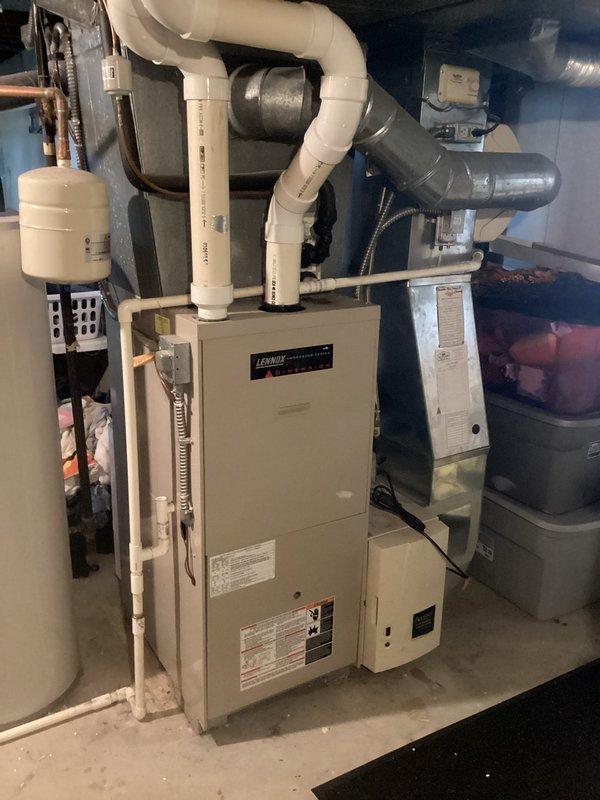 Conducted comprehensive site evaluation for complete HVAC system replacement including furnace and air conditioning equipment. Assessed existing Lennox furnace installation in mechanical room and exterior AC condenser unit mounted on concrete pad with associated electrical disconnect and metering equipment. Documented current system configuration including PVC venting, condensate drainage, electrical service connections, and ductwork connections. Evaluated mechanical room layout with existing water heater and hydronic system components to determine optimal equipment placement and clearance requirements. Inspected exterior condenser location, concrete pad condition, refrigerant line routing, and electrical service adequacy. Photographed all equipment nameplates, specifications, and existing installations to prepare accurate replacement estimate with appropriate equipment sizing and installation requirements.
