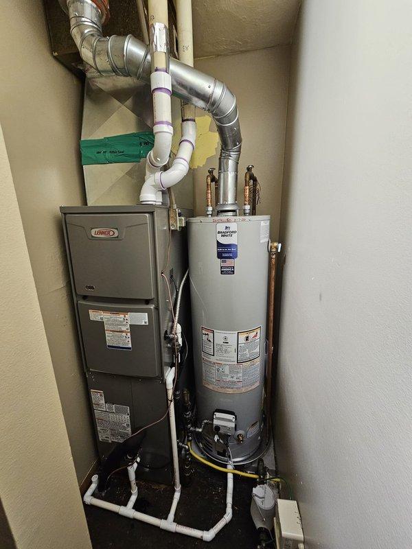 Removed existing Lennox furnace, air conditioning system, evaporator coil, and 40-gallon water heater to allow for floor replacement in utility closet. Obtained measurements for fabrication of new plenum to accommodate 70,000 BTU downflow furnace and 2.5-ton air conditioning system (AHRI Certificate #215586750). Equipment staged for reinstallation upon completion of flooring work, with new system including 40-gallon slim water heater.
