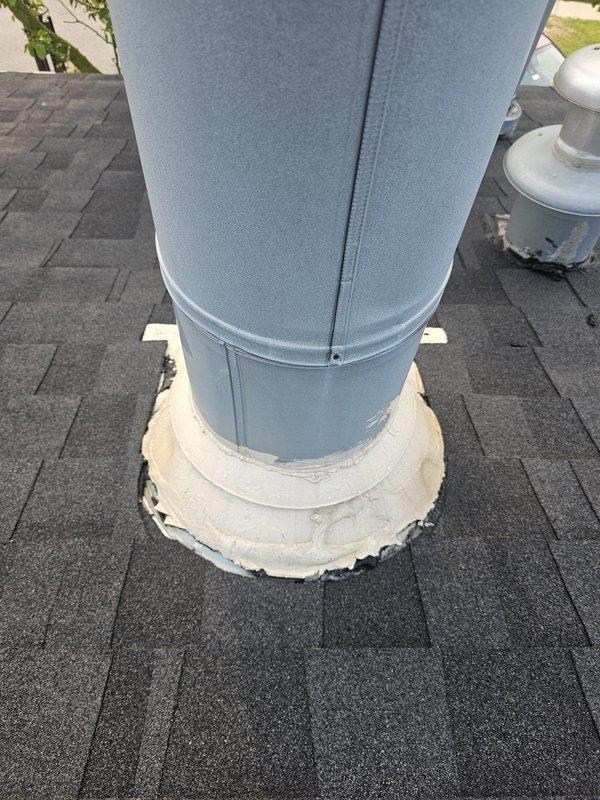 Responded to service call for roofing penetration assessment on mobile home undergoing roof replacement. Inspected and evaluated vertical duct flashing and stack penetrations to ensure proper sealing prior to completion of new roof installation. Examined existing white EPDM rubber boot surrounding large cylindrical duct penetration through asphalt shingle roof, confirming adequate weatherproofing and seal integrity around base where flashing meets shingles. Assessed sheet metal duct condition and paint finish for any signs of deterioration or potential leak points. Documented rooftop ventilation components and penetration installations with photographs for service records. Coordinated timing with roofing contractor to facilitate proper integration of plumbing stack and flue sealing with new roofing materials.