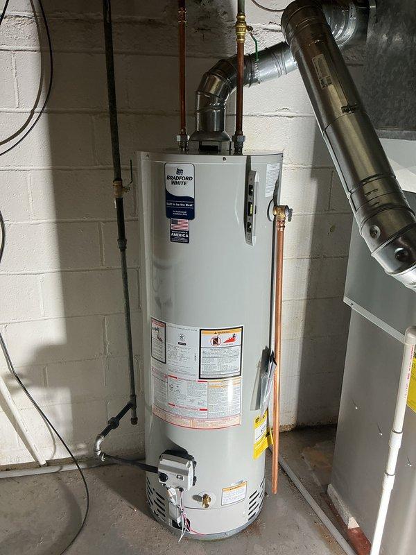 Completed water heater replacement in basement utility area. Removed existing unit and installed new Bradford White water heater, ensuring proper leveling and positioning on concrete floor against cinder block wall. Connected all copper supply lines, including hot and cold water connections with shutoff valves, and installed brass pressure relief valve. Verified all plumbing connections for proper fit and tested system for leaks. Installation completed in accordance with manufacturer specifications and local plumbing codes.