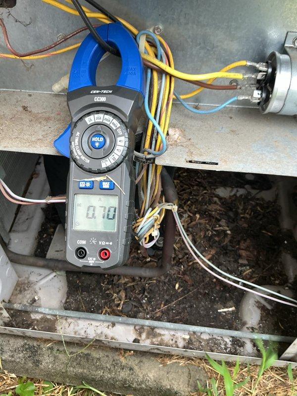 Responded to no-cooling complaint on central air conditioning system. Upon arrival, confirmed outdoor fan motor operating but noted absence of cold suction line temperature, lack of warm discharge air, and no condensate drainage—all indicating compressor failure. Used clamp meter to diagnose electrical issue, measuring 14.75 amps on one circuit and 0.70 amps on compressor circuit, confirming compressor not drawing proper amperage and failing to operate. Identified failed compressor as root cause preventing refrigeration cycle from functioning. Reviewed repair options and system age with customer to determine next steps for restoring cooling operation.
