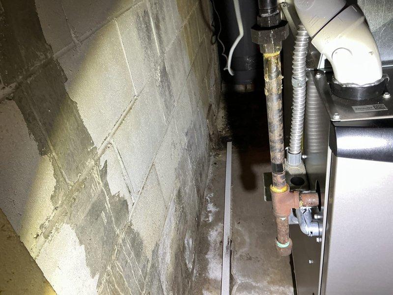 Responded to service call for condensation issue at customer vent location. Upon investigation, discovered significant moisture accumulation requiring exploratory access through ceiling material to identify source. Found evidence of condensate drainage concerns with visible water damage to surrounding surfaces and corrosion on copper piping components, indicating prolonged exposure to moisture conditions that required immediate attention and remediation.