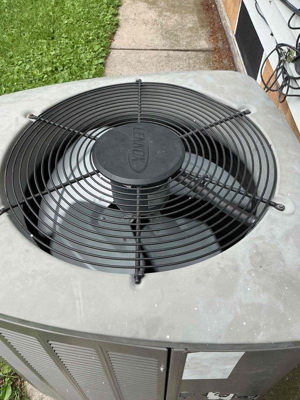 Responded to service call for 16-year-old air conditioning unit making loud noise after recent maintenance visit. Upon arrival, confirmed unit was cooling properly but producing excessive noise that stopped when pressure was applied to corner of condenser cabinet. Inspected outdoor condenser unit and fan assembly, identifying loose fan grille as source of vibration and noise. Secured fan guard mounting hardware and tightened all fasteners on top panel assembly. Verified proper fan operation and confirmed elimination of noise issue. Unit tested and operating within normal parameters with no abnormal sounds present.