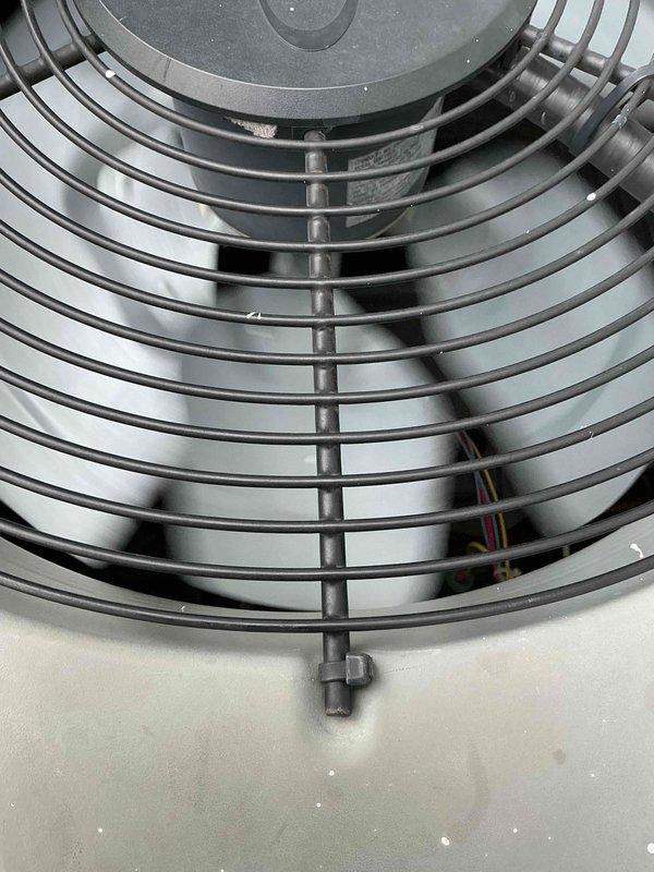 Responded to service call for 16-year-old air conditioning unit making loud noise after recent maintenance visit. Upon arrival, confirmed unit was cooling properly but producing excessive noise that stopped when pressure was applied to corner of condenser cabinet. Inspected outdoor condenser unit and fan assembly, identifying loose fan grille as source of vibration and noise. Secured fan guard mounting hardware and tightened all fasteners on top panel assembly. Verified proper fan operation and confirmed elimination of noise issue. Unit tested and operating within normal parameters with no abnormal sounds present.