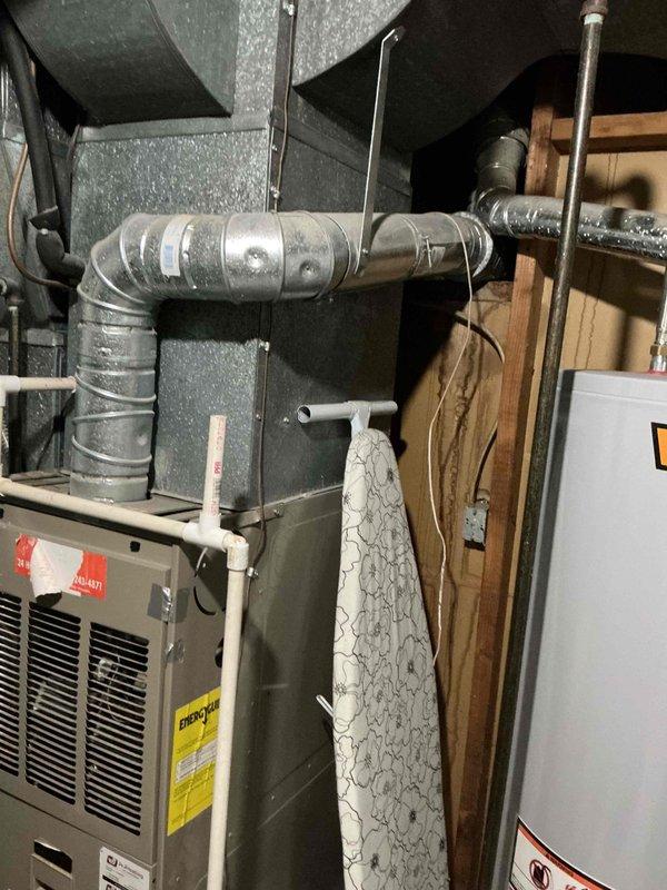 Responded to no cooling complaint on 15-year-old air conditioning system. Found ice formation on exterior refrigerant lines and moisture present on interior line, indicating restricted airflow or low refrigerant charge. Customer had turned system off overnight prior to service call. Inspected air filter which was replaced in July but noted system age of approximately 15-16 years. Evaluated HVAC equipment installation including furnace unit, ductwork connections, and associated mechanical components in utility space. Documented system condition and advised customer on findings related to ice buildup and cooling performance issues.
